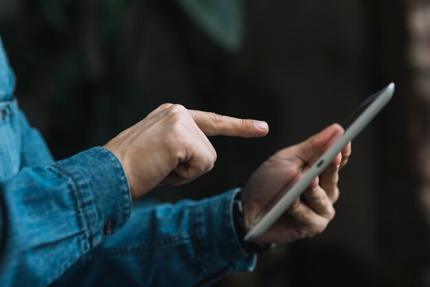 Close-up of man pointing finger over the digital tablet