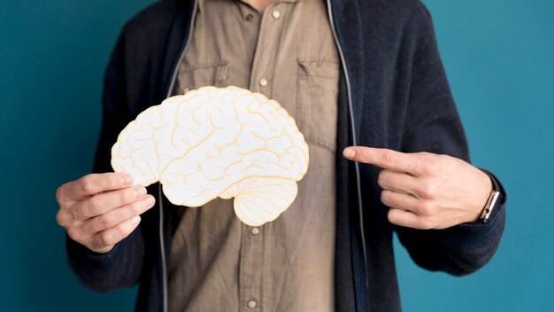 Close-up man pointing at paper brain