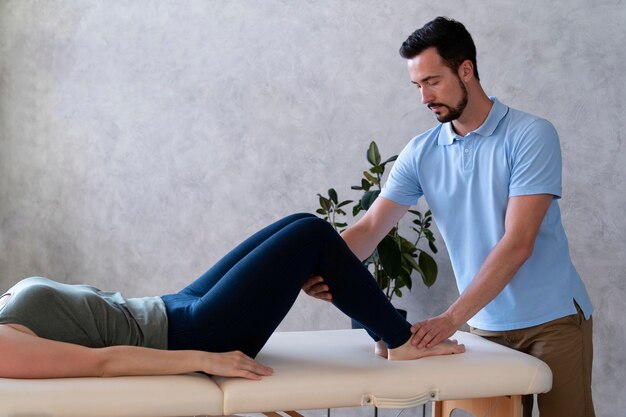 close up man positioning patient legs