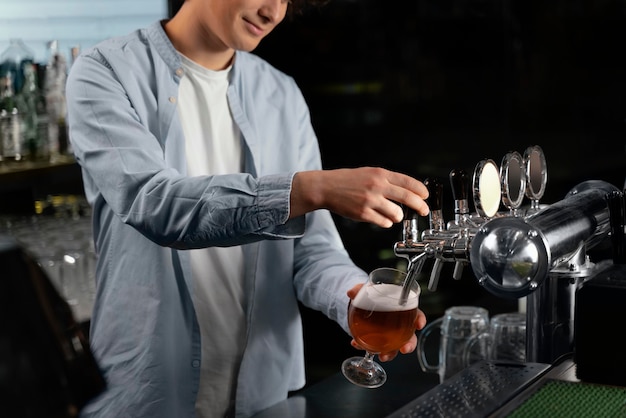 Foto gratuita uomo del primo piano che versa birra in vetro