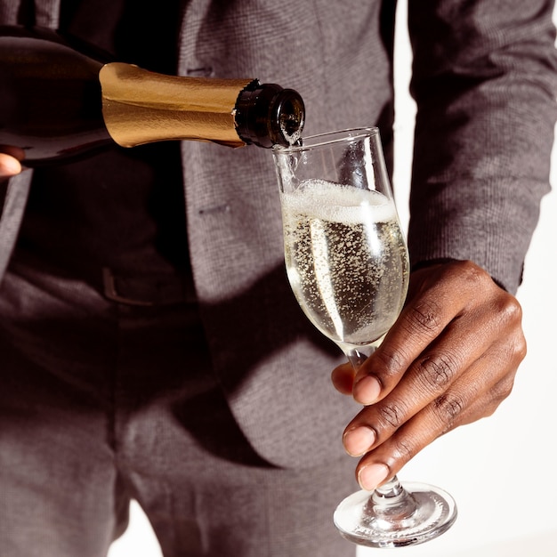 Close-up man pouring champagne in bottle