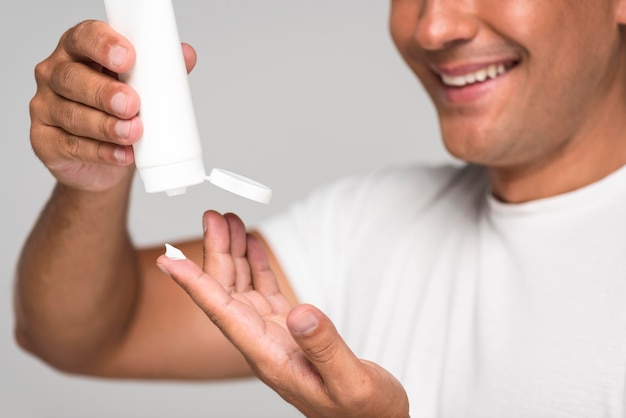 Close-up man pouring cream