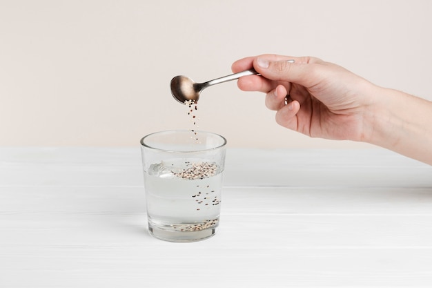 Free photo close-up man pouring seeds in a glass