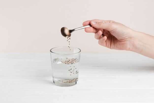 Close-up man pouring seeds in a glass