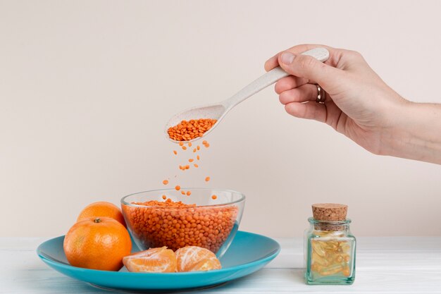 Close-up man pouring seeds with spoon