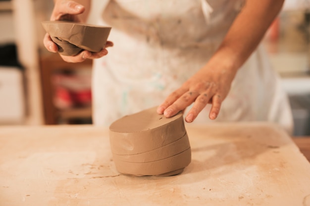 Close-up of a man preparing the clay on wooden table