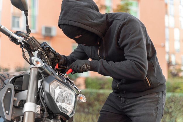 オートバイを盗む準備をしている人にクローズアップ