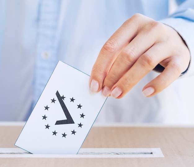 Free photo close-up man putting in a box a ballot