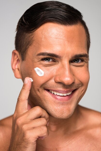 Close-up man putting on  cream