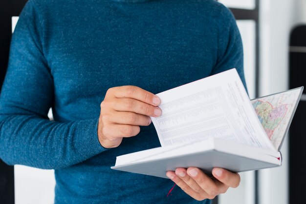 Close-up man reading book and changing pages