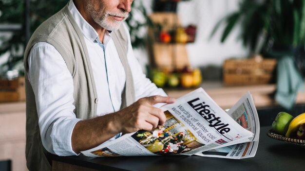 close-up of man reading newspaper
