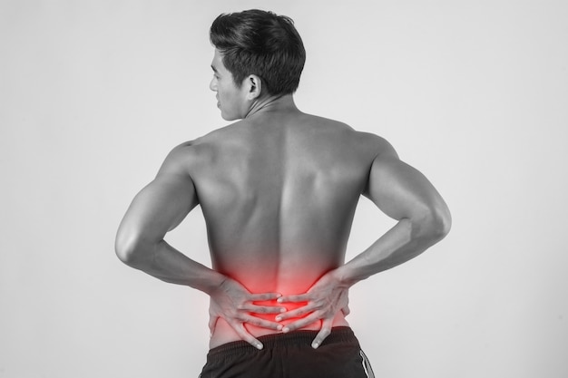 Close up of man rubbing his painful back isolated on white background.