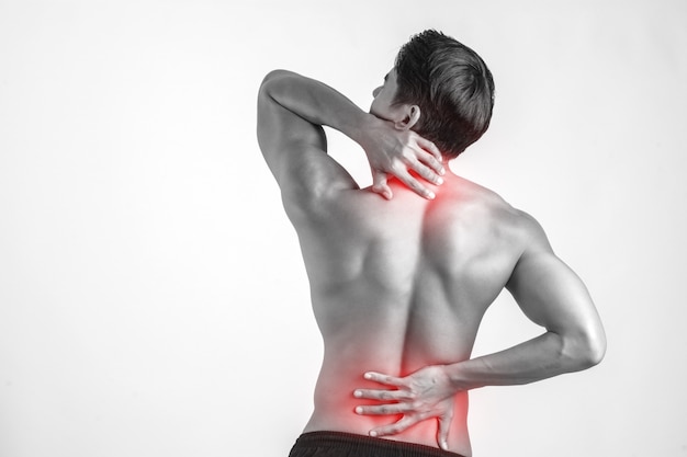 Close up of man rubbing his painful back isolated on white background.