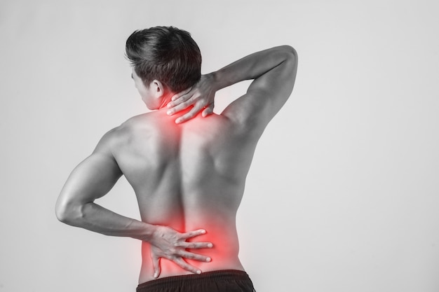 Close up of man rubbing his painful back isolated on white background.