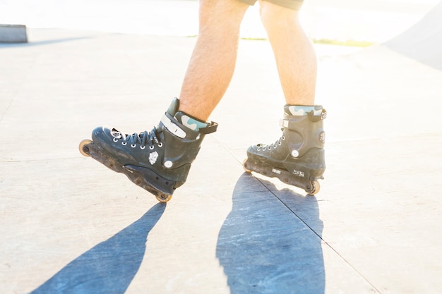 Close-up of a man's feet rollerskating in skate park