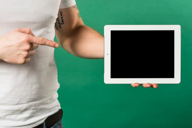 검은 화면 디스플레이와 디지털 태블릿을 향해 손가락을 가리키는 사람의 손가락의 근접