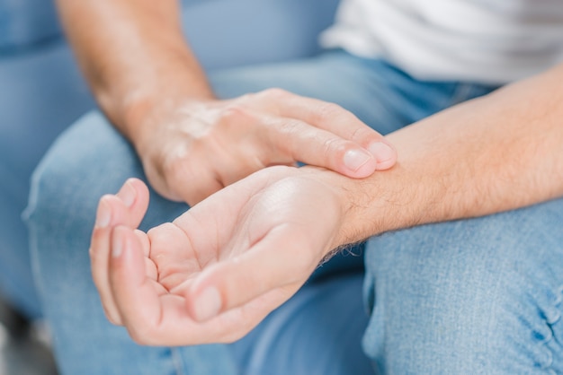 Close-up of a man's hand checking pulse