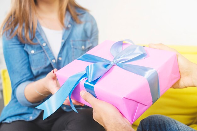 Close-up of man's hand giving gift to his girlfriend