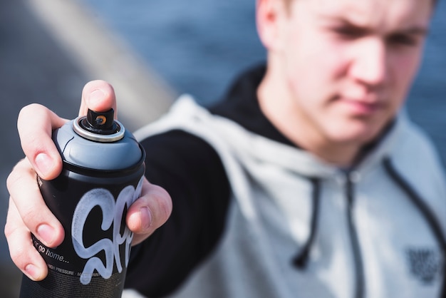 Close-up of a man's hand holding aerosol spray can