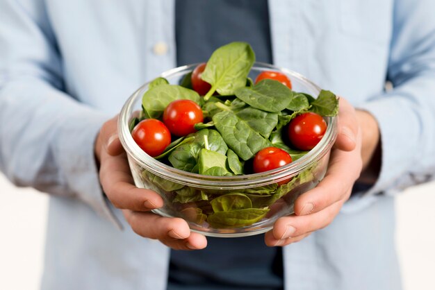 Close-up of man's hand holding bowl of salad