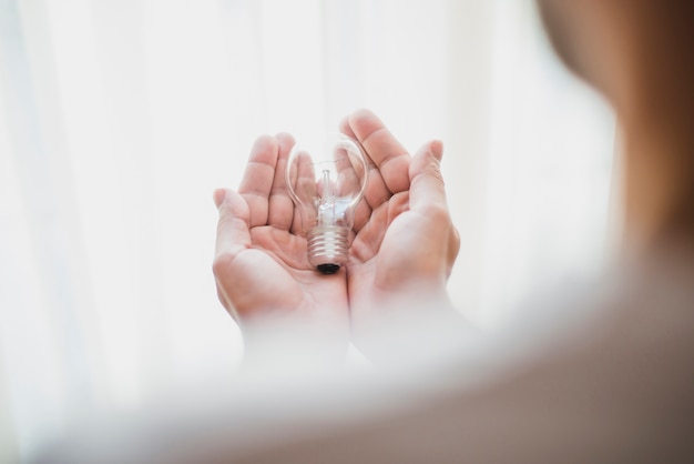 Close-up of man's hand holding light bulb