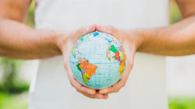 Close-up of man's hand holding small globe