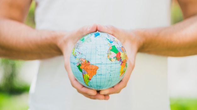 Close-up of man's hand holding small globe