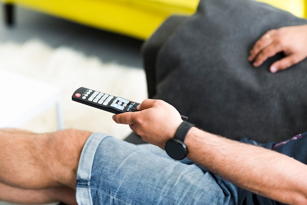 Close-up of man's hand holding television remote control