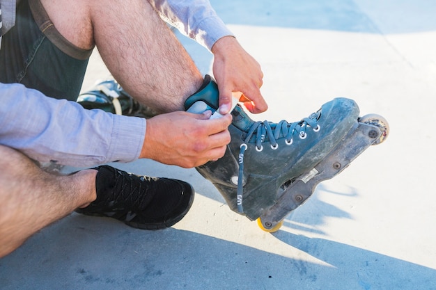 Close-up of a man's hand putting on rollerskate