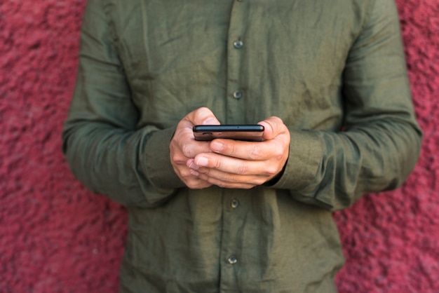 Primo piano della mano dell'uomo tramite cellulare