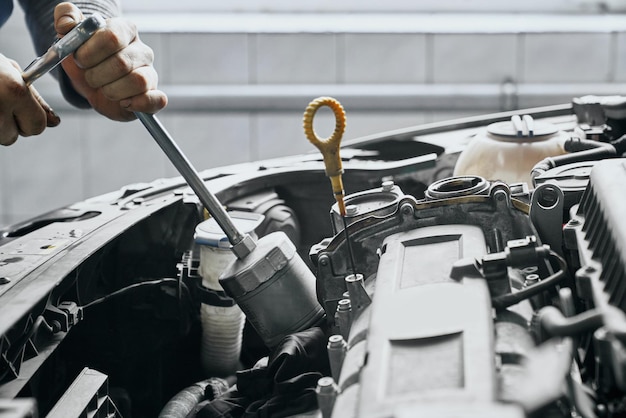 Close up of man's hands tighten piston cylinder by wrench