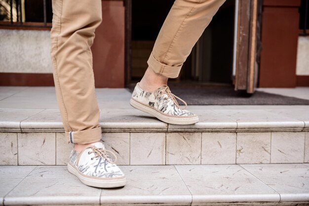 Close up of man's legs in keds going down stairs