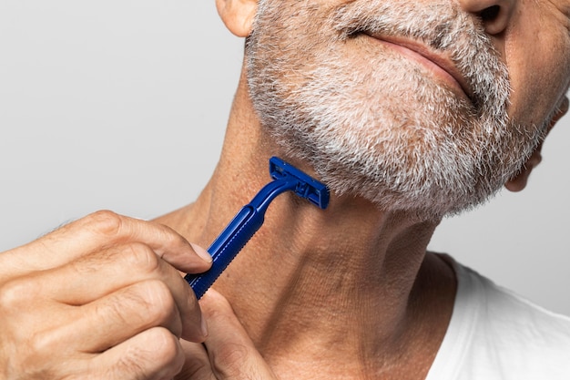 Free photo close-up man shaving his neck