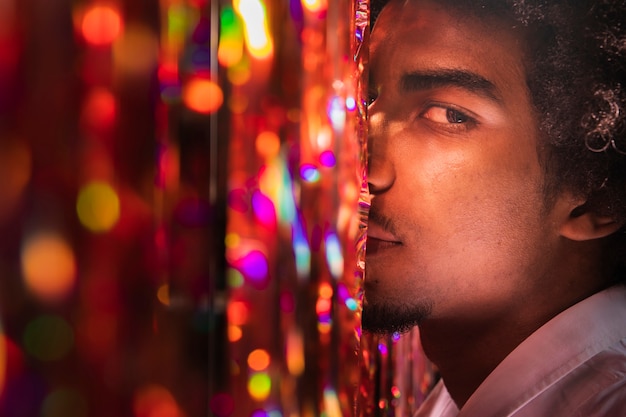 Close-up man side view and curtain of sparkles