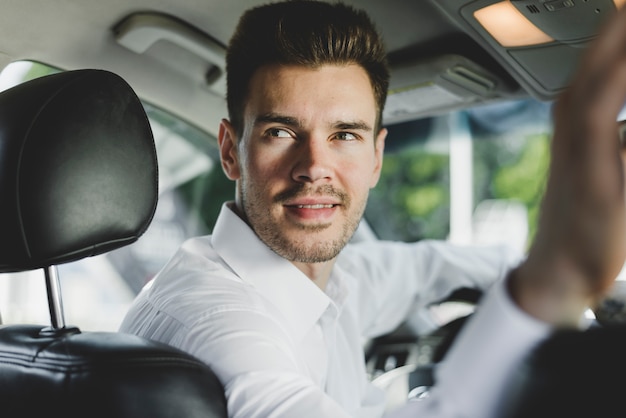 Close-up of man sitting in the car looking back