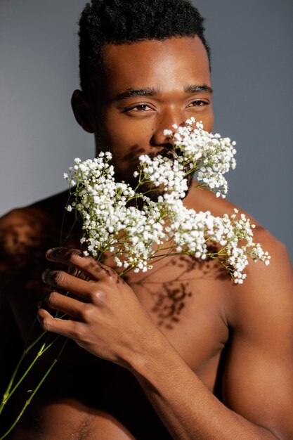 Close-up man smelling flowers
