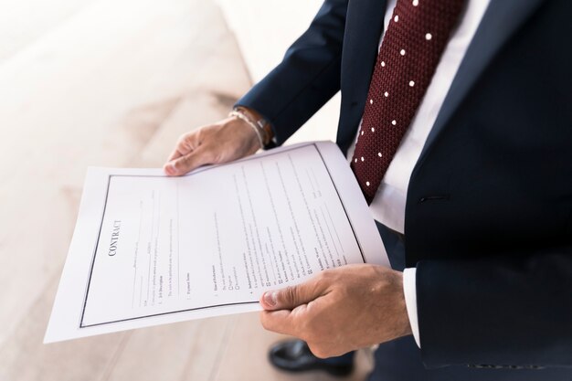 Close-up man in suit holding a contract