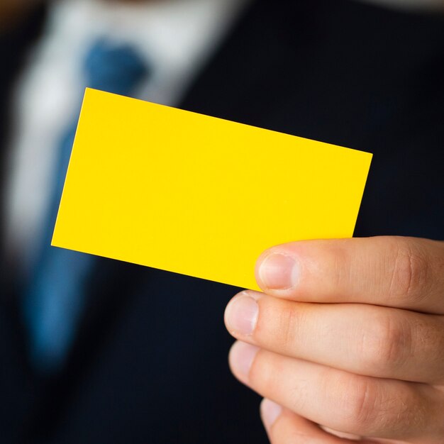 Close-up man in suit with business card