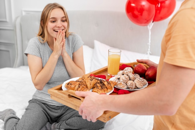 Close-up man surprising woman with breakfast