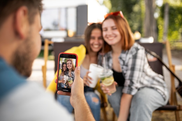 Close up man taking photos with smartphone