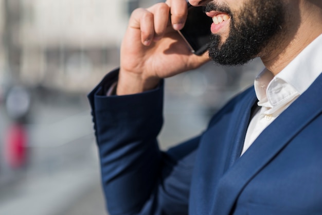 Uomo del primo piano che parla sopra il telefono