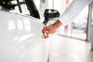 Free photo close-up man testing car at dealership