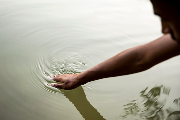 Uomo del primo piano che tocca l'acqua