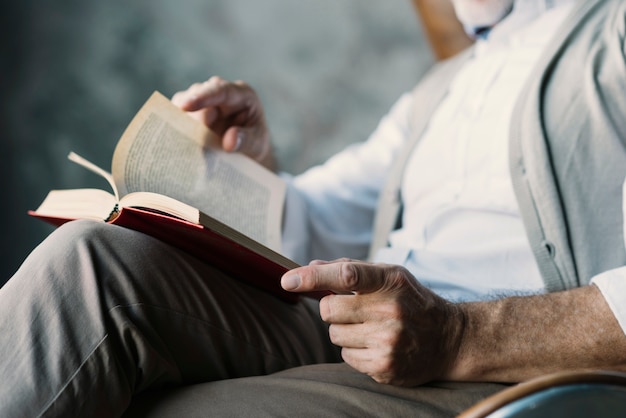 Foto gratuita primo piano dell'uomo che gira le pagine del libro