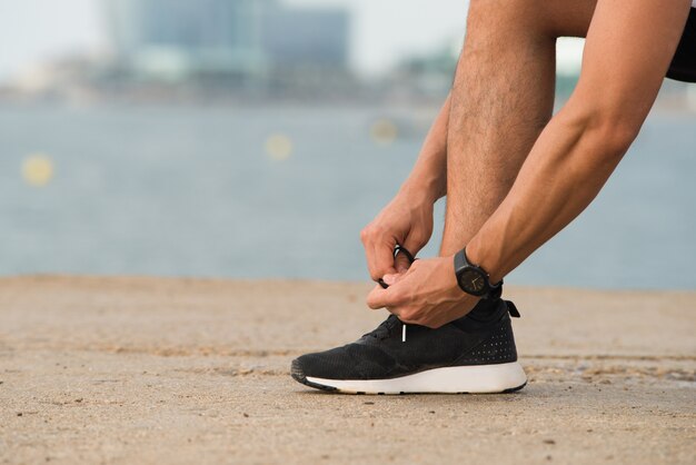 Close-up of man tying shoelaces outdoors