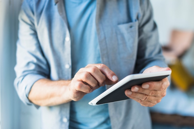 Close-up of man using digital tablet