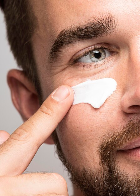 Close-up of man using face cream