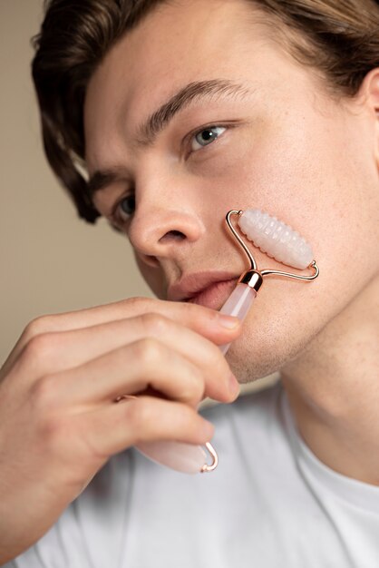 Close up man using gua sha tool