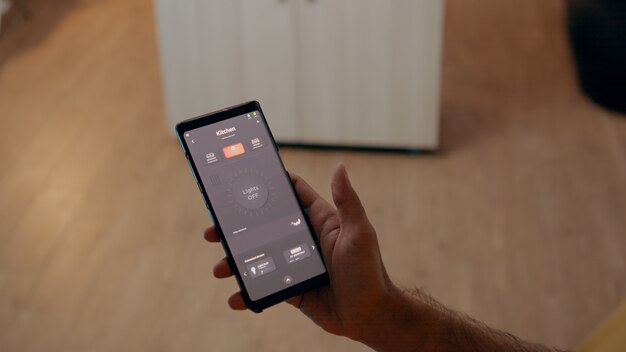 Close up of man using voice activated application to turn on bulbs in smart home with automation system