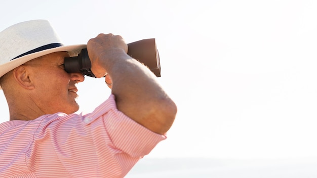 Close-up man watching through binoculars